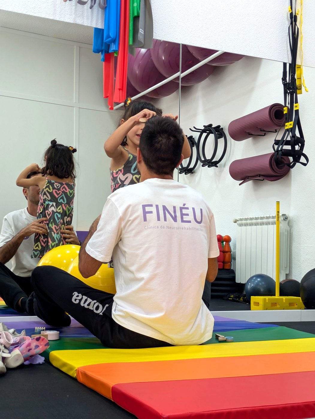Fisioterapeuta de Clínica Finéu jugando con una niña en la sala de fisioterapia
