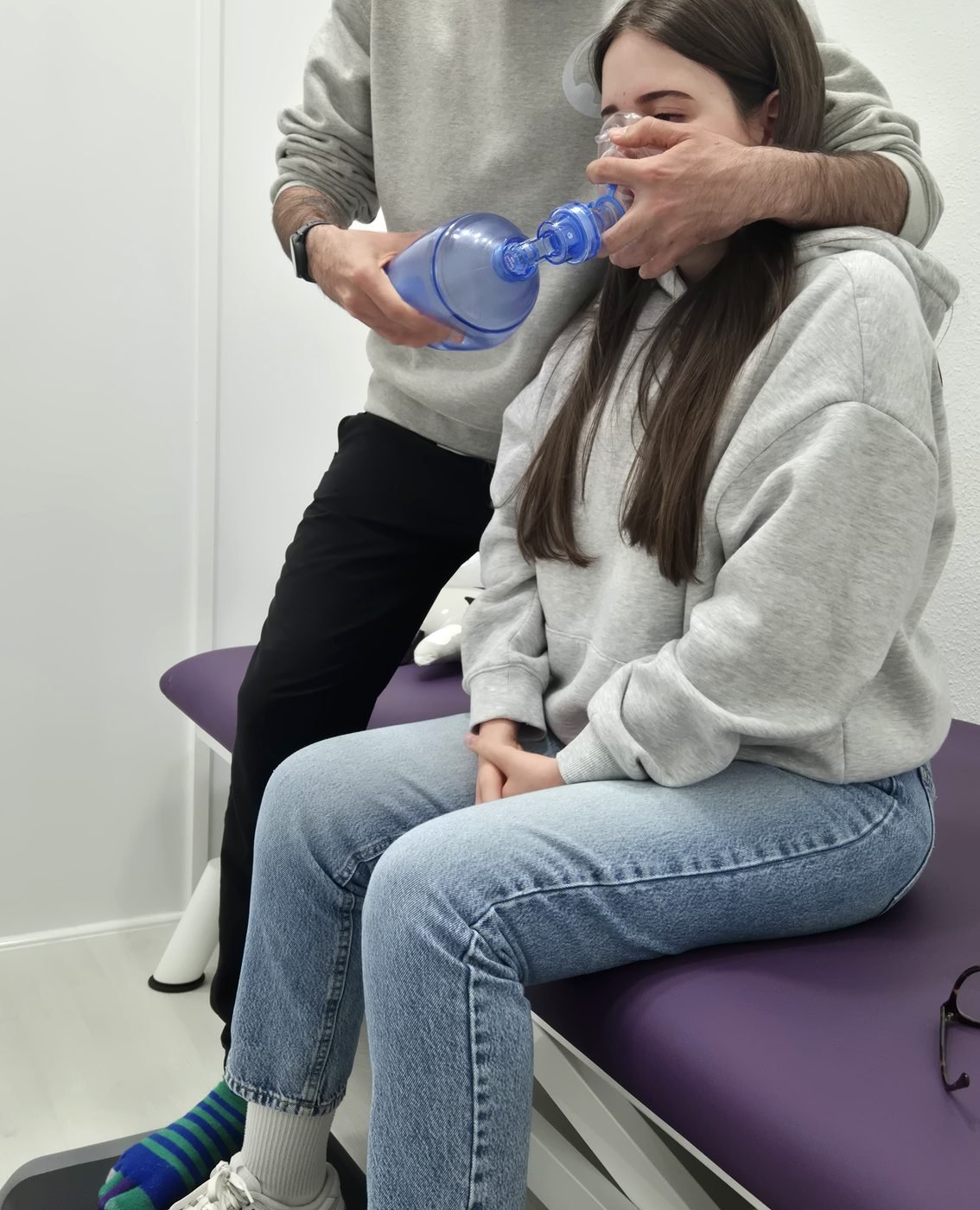 Fisioterapeuta de Clínica Finéu aplicando terapia respiratoria con ambú a una paciente